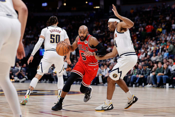 Chicago Bulls guard Jevon Carter (5) controls the ball against Denver Nuggets guard Jalen Pickett (24) in the first quarter at Ball Arena.